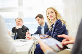 eine Gruppe von Menschen, die um einen Tisch sitzen