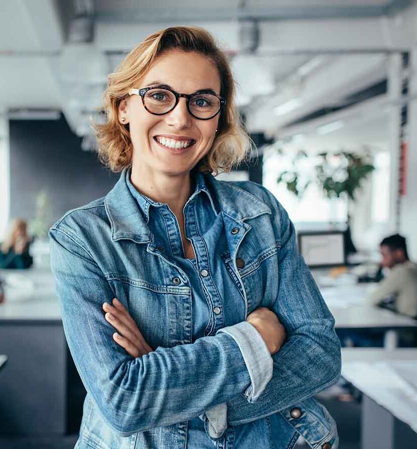 eine Frau in einem Büro mit gekreuzten Armen